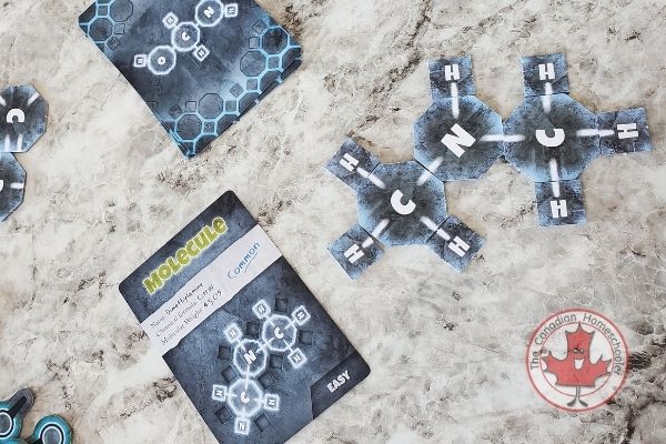 Picture of the pieces of a board game called Covalence from Genius Games where you make molecules from clues.
